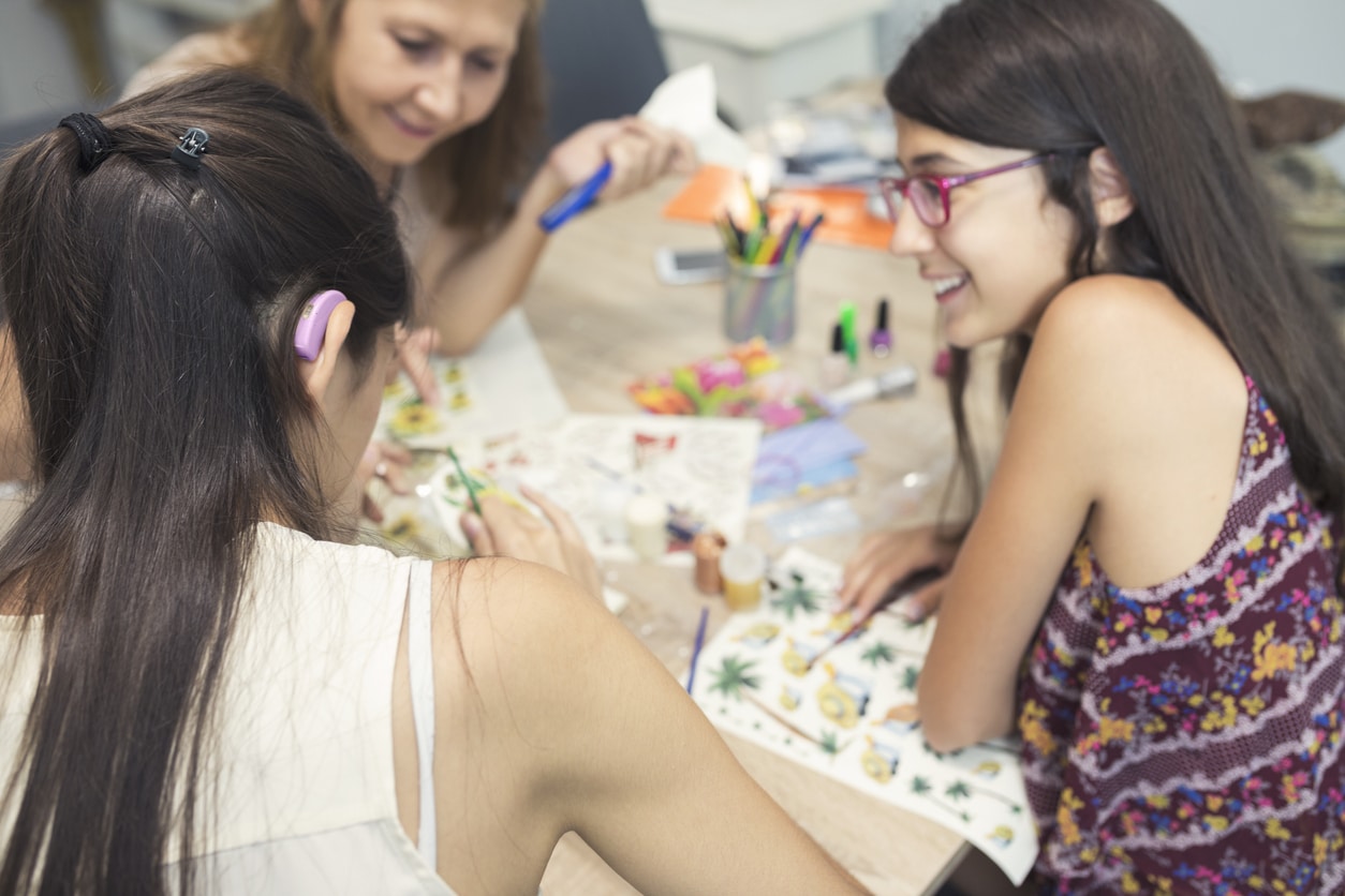 Teenage girl with a hearing aid hanging out with her friends.