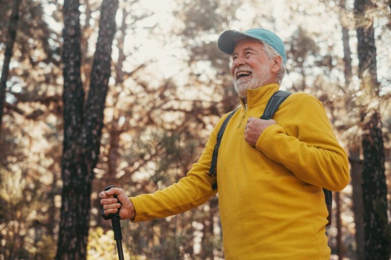 man smiling on a hike in the woods