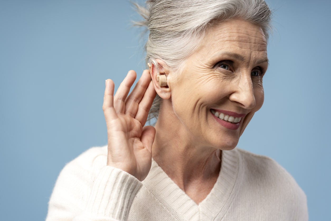 Senior woman showing off her BTE hearing aid