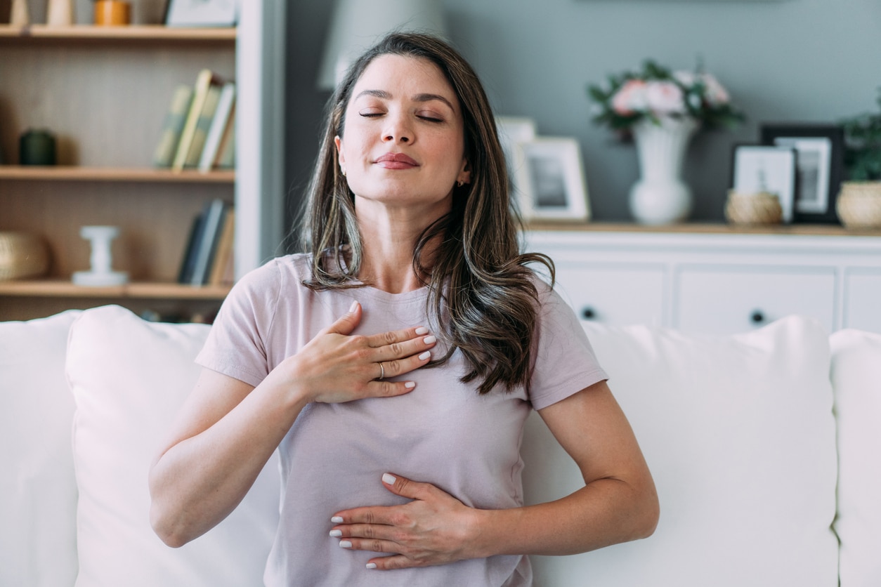 Woman doing calming breathing exercises at home