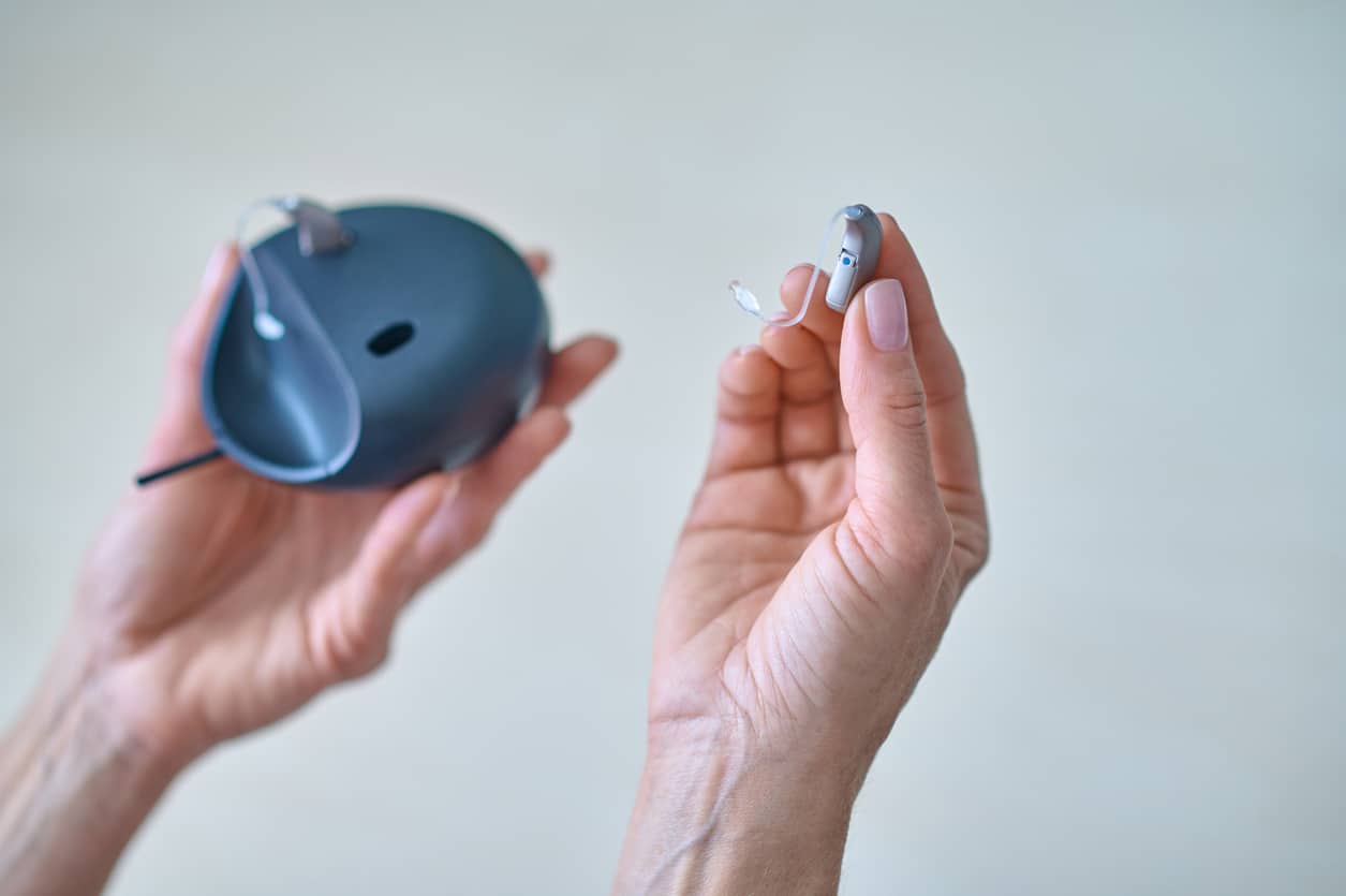 Hand removing a hearing aid from its case