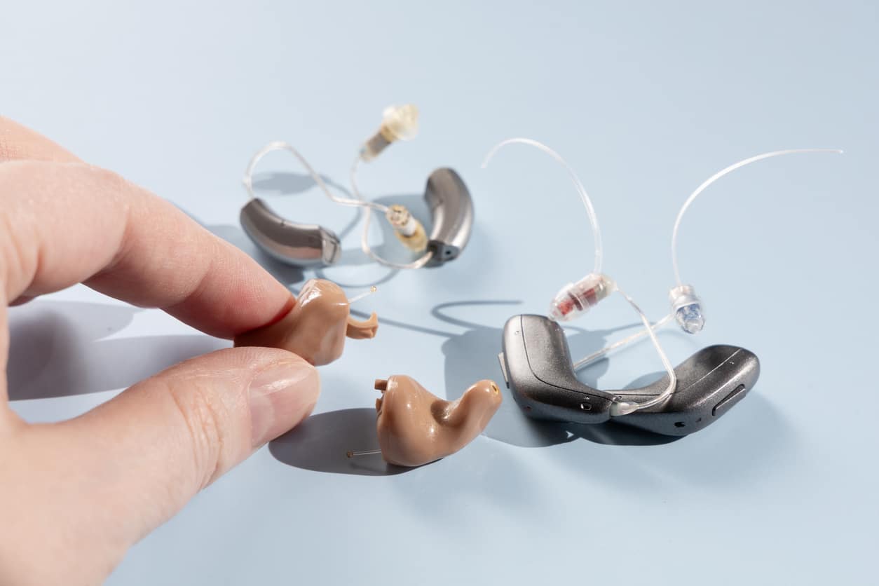 Hand holding modern hearing aid